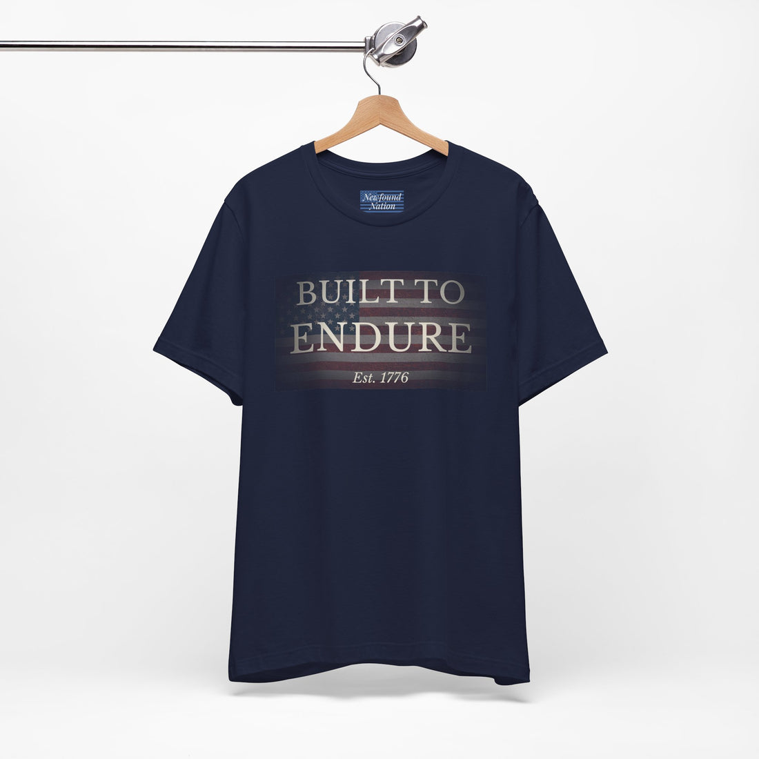 Built to Endure T-Shirt - Patriotic Est. 1776 Tee displayed on a hanger with minimalist design.