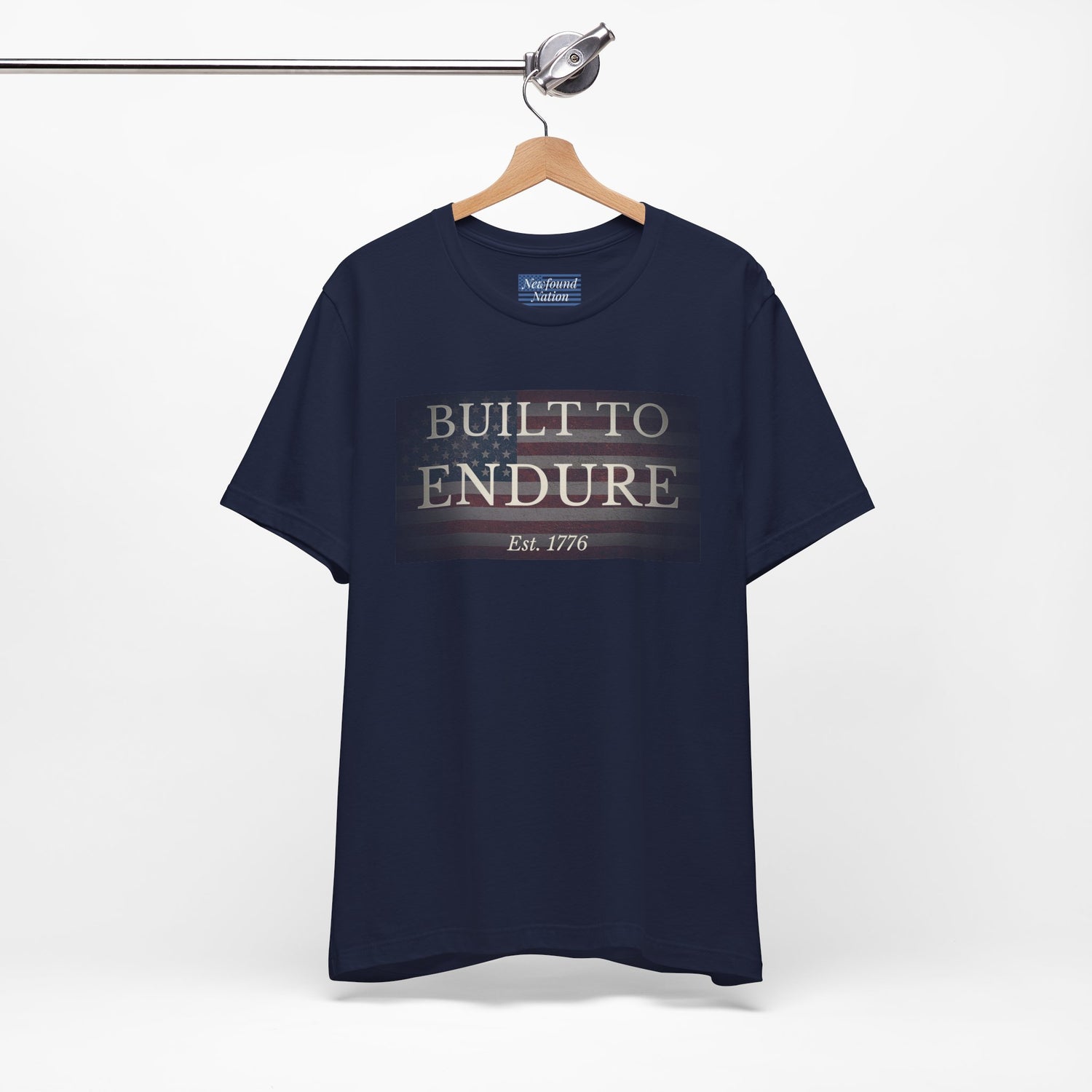 Built to Endure T-Shirt - Patriotic Est. 1776 Tee displayed on a hanger with minimalist design.