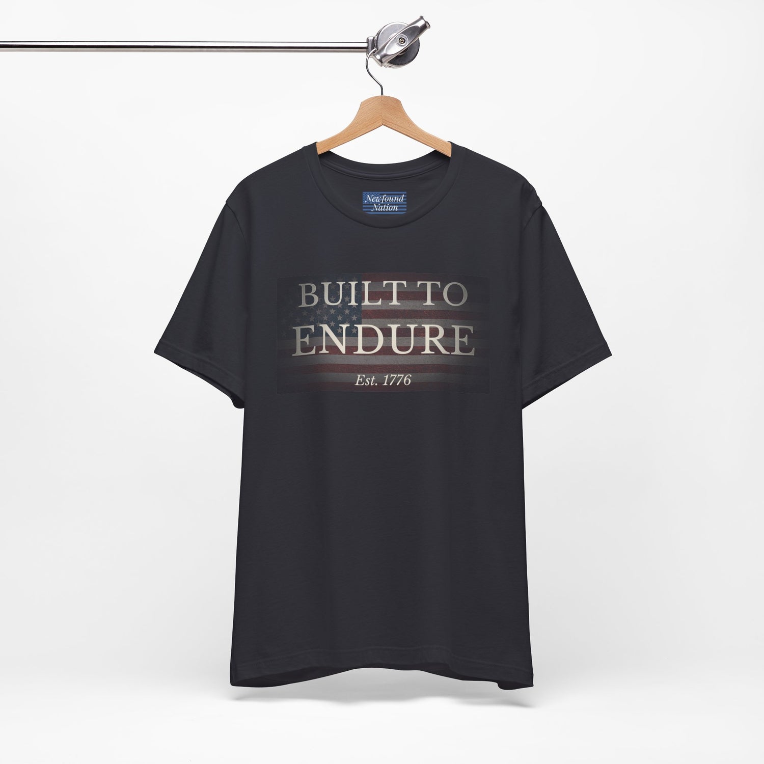 Built to Endure T-Shirt - Patriotic Est. 1776 Tee displayed on a hanger with minimalist design.